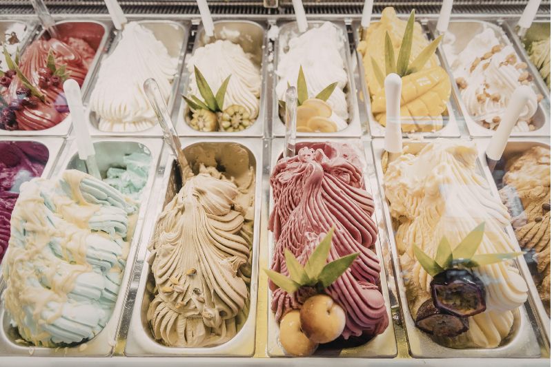 Vetrina di gelato artigianale con diversi gusti alla frutta e alle creme in una gelateria di Bergamo