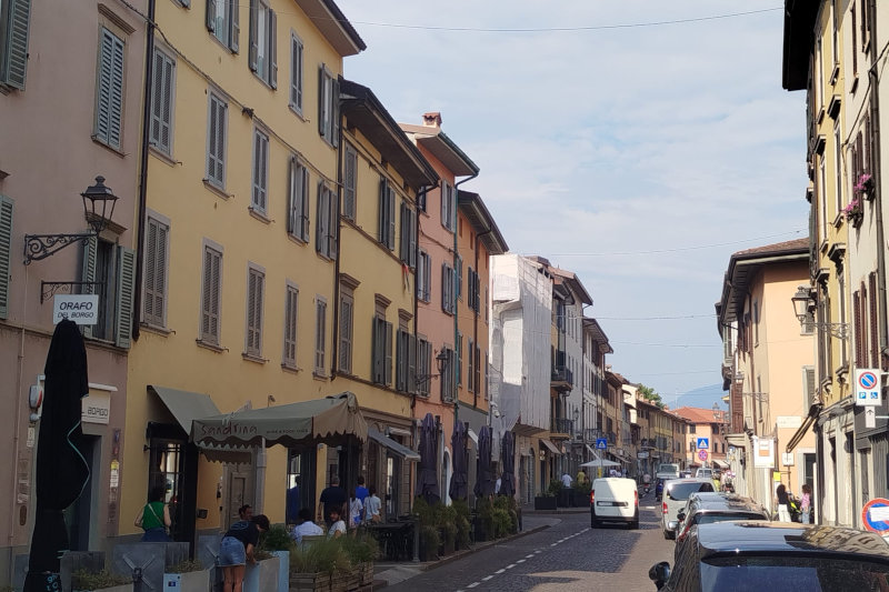 Via principale di Borgo Santa Caterina a Bergamo con edifici storici, locali e negozi