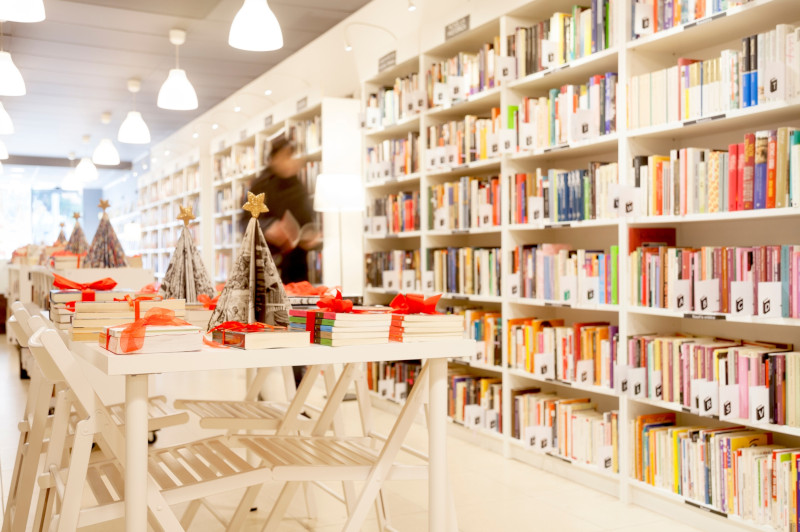 Esposizione di libri e volumi regalo su un tavolo in una libreria addobbata per Natale